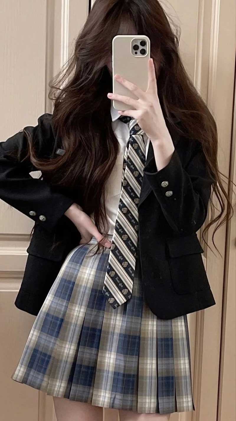 Ảnh nữ xinh che mặt bằng điện thoại phối outfit trắng đen.