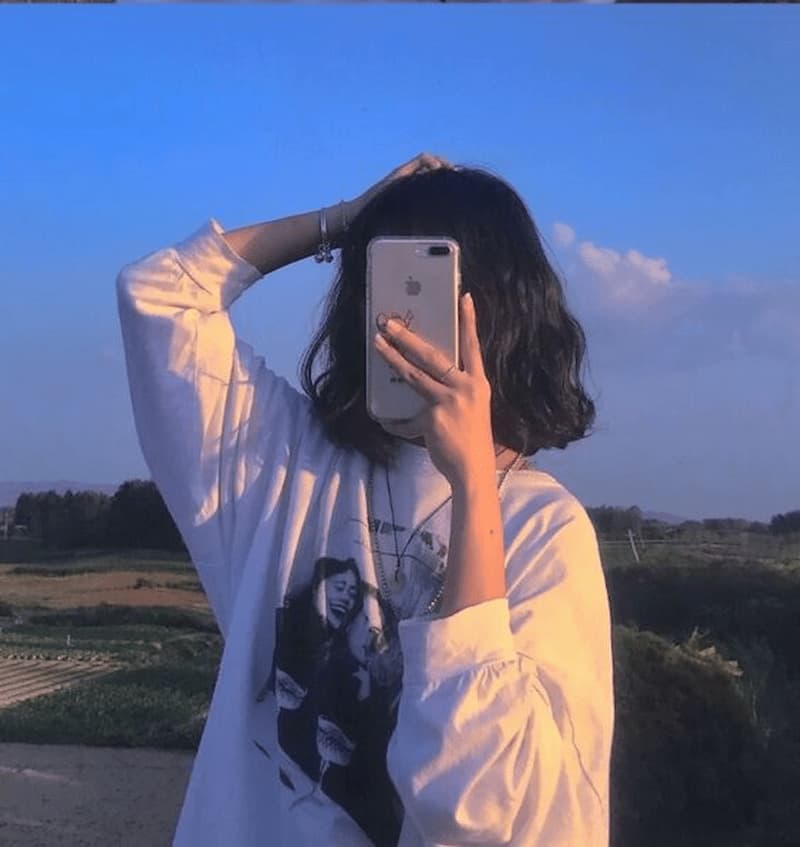 Gái xinh tóc tém che mặt trong khung hình thiên nhiên.