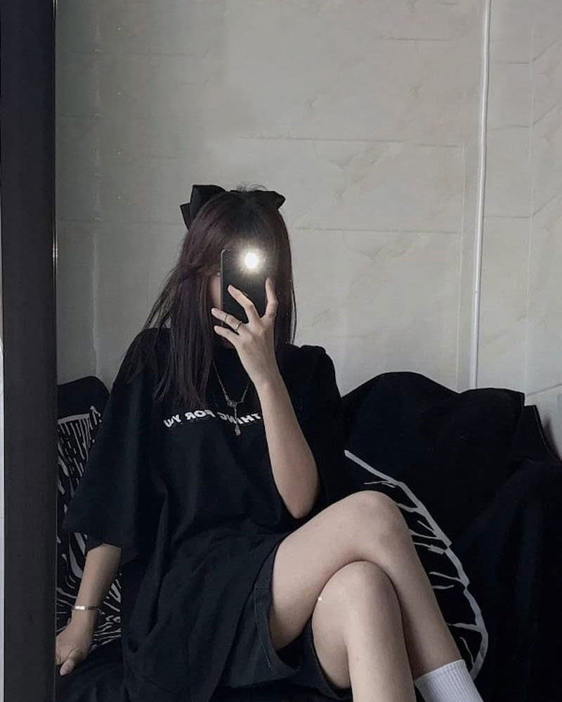 Hình ảnh nữ che mặt với nơ cute và outfit màu đen.