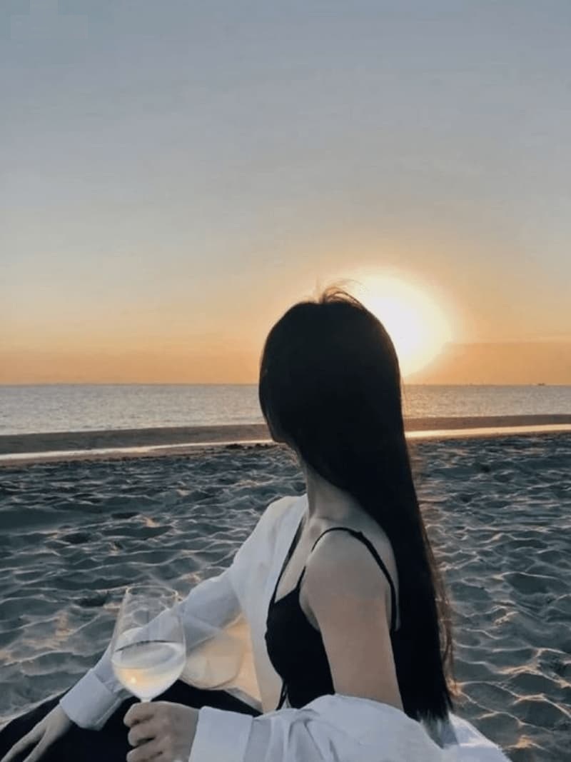 Ảnh gái mạng che mặt tạo dáng ngồi với ánh sáng dịu hoàng hôn.