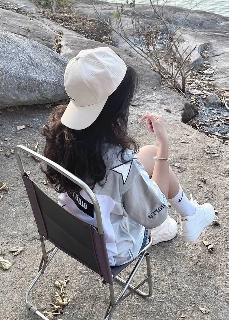 Gái mạng che mặt đội baseball cap phối cùng outfit streetwear.